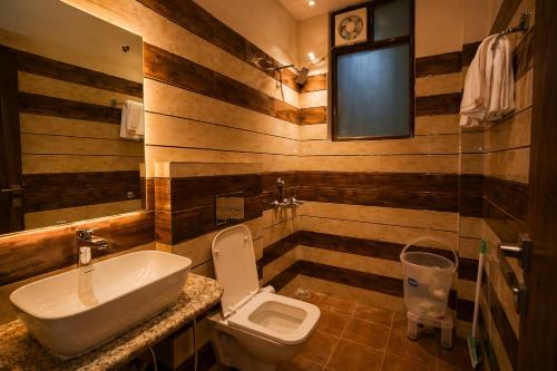 a bathroom with a sink and a toilet at Aesquire Hotel in Bhīm Tāl