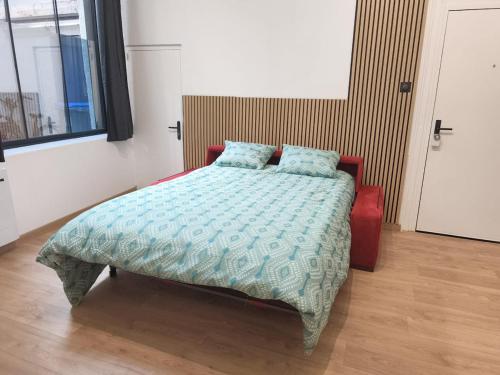 a bedroom with a bed with a blue comforter at Le Cleyputz in Dunkerque