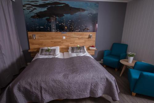 a bedroom with a bed and a blue chair at Grimstad Vertshus in Grimstad