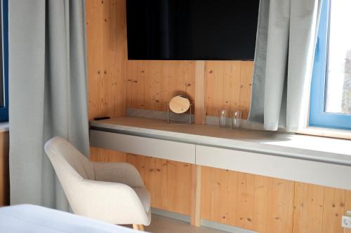 a room with a television and a chair and a window at Casa Brutarului in Timişoara