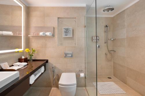 a bathroom with a shower and a toilet and a sink at Welcomhotel by ITC Hotels, Dwarka, New Delhi in New Delhi
