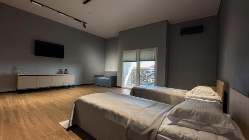 a bedroom with two beds and a large window at Готель «ТАВЕРНА» in Ovruch