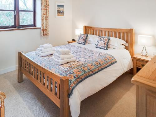 a bedroom with a large bed with towels on it at Jacks Barn - Hssu in Welcombe