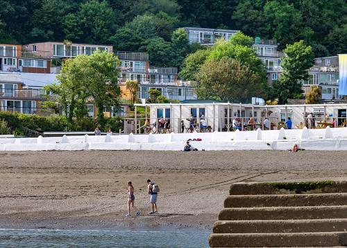 a group of people standing on the beach at Millendreath Beach Resort in Looe