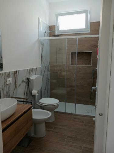 a bathroom with a toilet and a sink and a window at A Casuzza in Balestrate