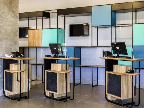 a room with two tables with laptops on them at ibis Ribeirao Preto Vila do Golf Shopping in Ribeirão Preto