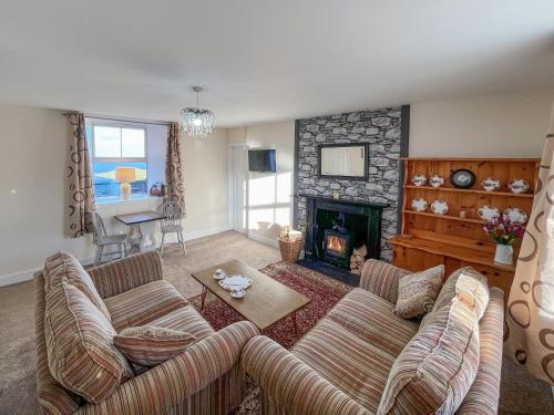a living room with a couch and a fireplace at Ballygroggan Cottage - Uk48768 in Machrihanish