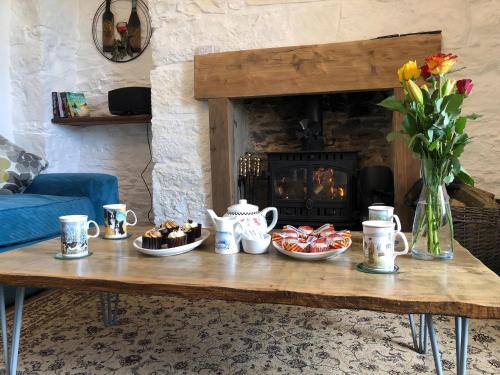 a coffee table with cookies and a vase of flowers at Ballygroggan Farmhouse - Uk35208 in Machrihanish