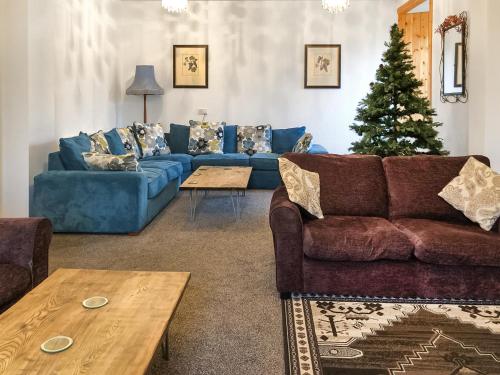 a living room with blue couches and a christmas tree at Ballygroggan Farmhouse - Uk35208 in Machrihanish