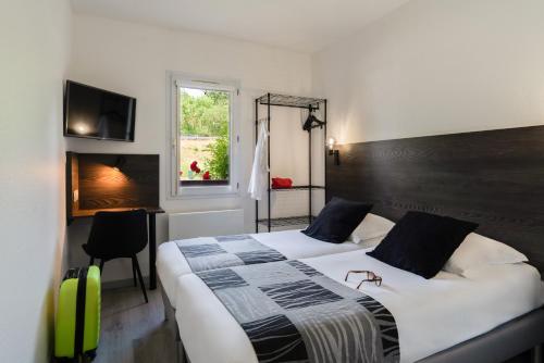 a hotel room with two beds and a window at The Originals Access, Halt'Hotel, Clermont Agnetz in Agnetz