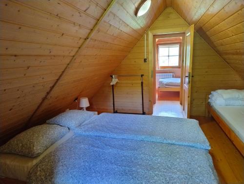 a bedroom with a bed in a wooden cabin at Chatka w gorach in Lewin Kłodzki