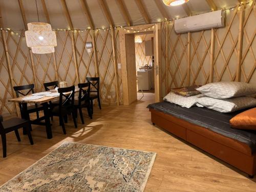 a room with a table and a bed in a yurt at Jurajskie Jurty in Golczowice