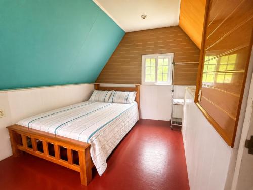 a small bedroom with a bed in a attic at Cabaña El Cafetal in Valle Hornito