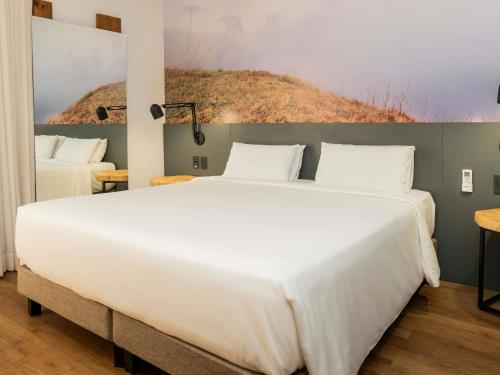 ein Schlafzimmer mit einem großen weißen Bett in einem Zimmer in der Unterkunft Novotel Criciuma in Criciúma