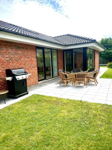 a patio with chairs and a grill in front of a house at Spacious Luxury Villa in Copenhagen in Copenhagen