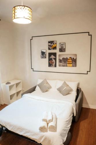 a bedroom with a bed with slippers on it at Zen Suite - 50m from Metro M1 - Direct to F1 Monza, Fashion Week, Duomo in Milan