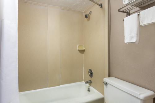 a bathroom with a white toilet and a shower at Super 8 by Wyndham Locust Grove in Locust Grove