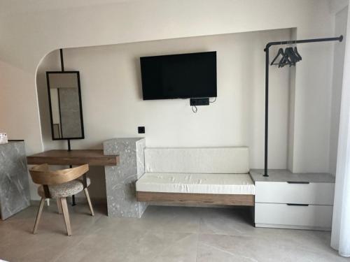 a living room with a couch and a tv on the wall at 7 Suites in Skiathos
