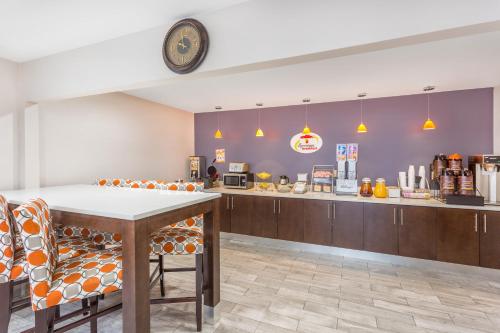 a restaurant with a table and chairs and a counter at Super 8 by Wyndham Locust Grove in Locust Grove