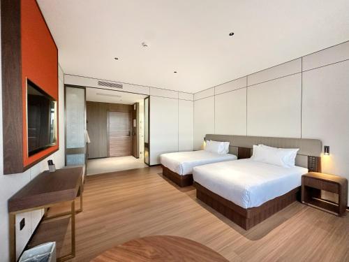 a hotel room with two beds and a television at Hotel Hualton in Alcobendas