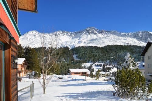 a view of a snowy mountain from a house at Golden Peaks Ferienhaus Valbella-Lenzerheide in Valbella