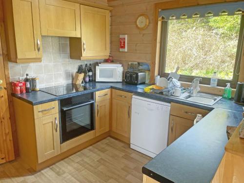 a kitchen with wooden cabinets and a counter top at The Brown House in Woolfardisworthy