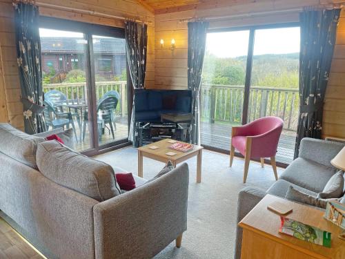 a living room with two couches and a balcony at The Brown House in Woolfardisworthy