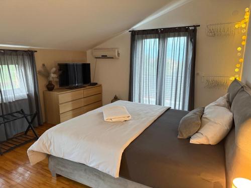 a bedroom with a large bed and a television at Ferienhaus Marija mit Pool in Vilanija
