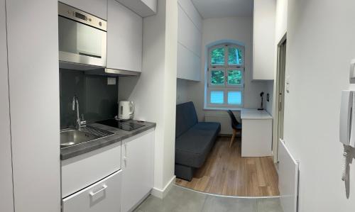 a small kitchen with white cabinets and a sink at Apartament Gdański Harward lokal nr 2 in Gdańsk