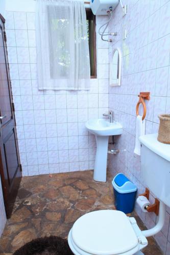 a bathroom with a toilet and a sink at Caffè Roma l'originale in Kampala