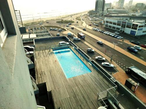 a swimming pool on the side of a building next to a road at 404 Horizon Bay in Bloubergstrand