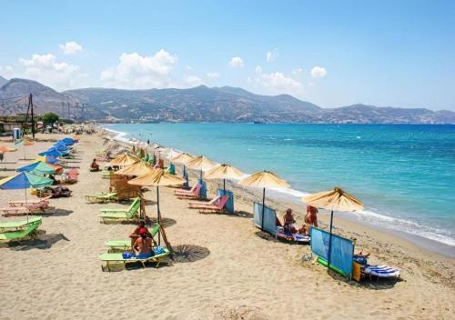a beach with umbrellas and people sitting on the sand at Apartment Simply 206 in Gázion