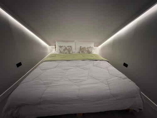 a bedroom with a large bed in a white room at Casa Attika - Modern Glasshouse with Skyline Views in Antipolo