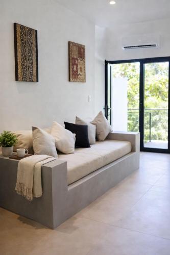 a couch in a living room with a large window at Las Naveiras in Tamarindo