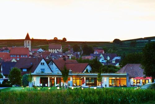 a house with lights in front of a town at Kreuz-Post Hotel-Restaurant-SPA in Vogtsburg