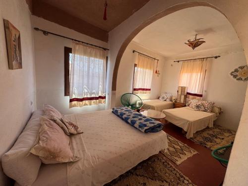 ein Zimmer mit einem Bett und ein Wohnzimmer mit einer Couch in der Unterkunft Citadelle Gorges in Aït Ben Ali