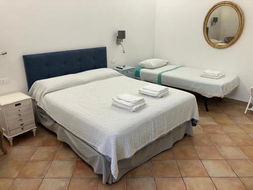 two beds in a room with a mirror at Casa Mille Lire in Ciampino