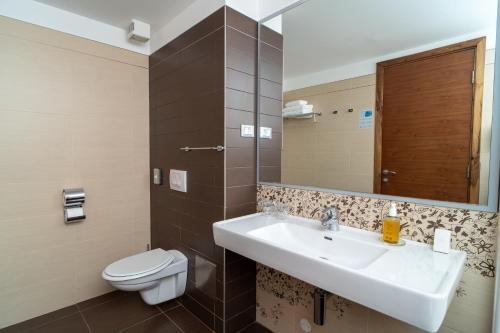 a bathroom with a sink and a toilet at Hotel Lipa in Postira
