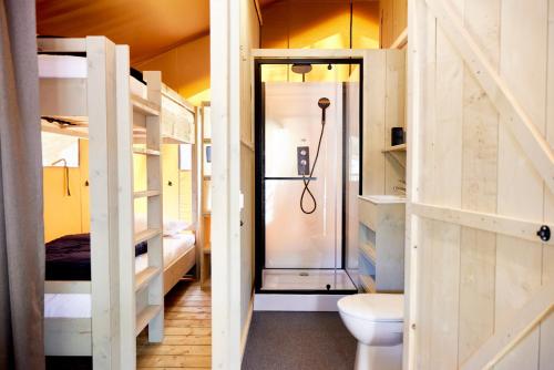 a bathroom with a shower and a toilet in a room at Glamping Sistiani in Lido di Spina
