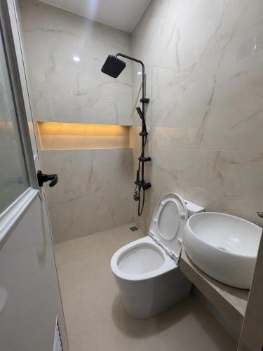 a bathroom with a toilet and a sink and a shower at Casa Attika - Modern Glasshouse with Skyline Views in Antipolo