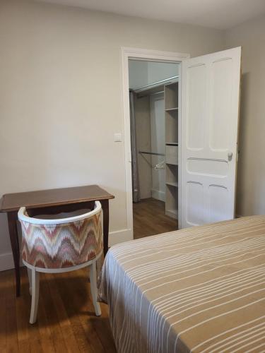 a bedroom with a desk and a bed and a table at Appartement proche Taizé Cluny in Massilly