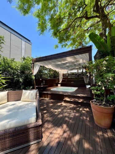 a wooden deck with a bed and a tub at Nova Pousada dos Chás in Florianópolis