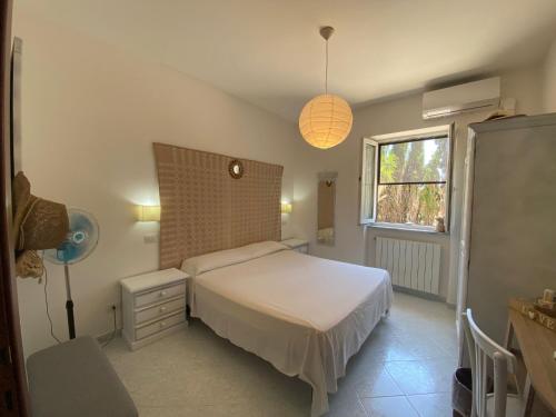 a bedroom with a white bed and a window at Anna Rita Alghero B&B in Fertilia