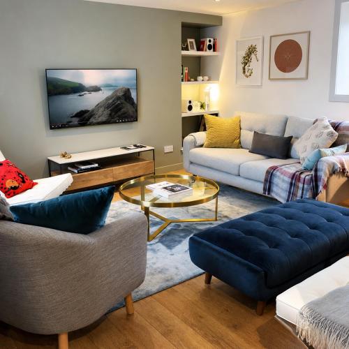 a living room with two couches and a tv at Aald Harbour Hoose, Shetland Islands in Lerwick