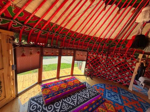 a room with a bed and windows in a yurt at Bermet guest house in Karakol
