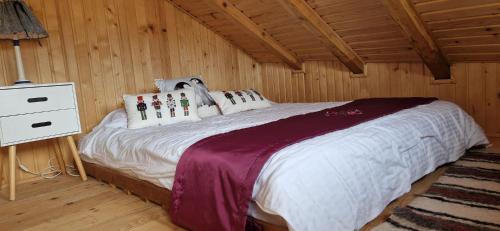 a bedroom with a bed in a wooden cabin at Casuta Letitiei in Şirnea