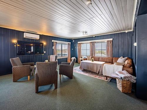 a living room with a couch and a table and chairs at Stølsdokken Lodge in Sanderstølen