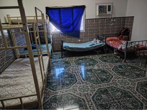 a room with bunk beds and a tiled floor at Turkish beach hostel in Muscat