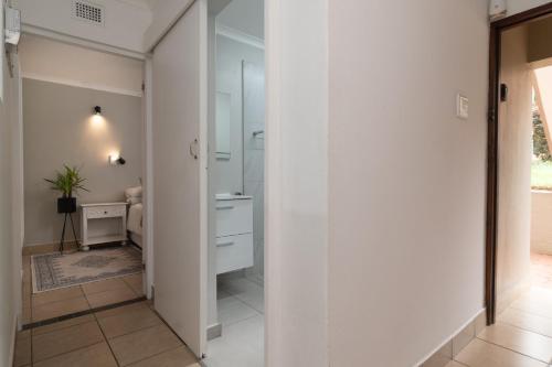 a hallway with a bathroom with a sink and a mirror at Ballito Beachfront Resort - 34 Chaka Chalets in Ballito