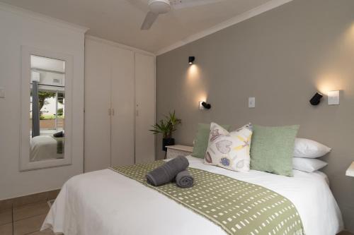 a bedroom with a large white bed with pillows at Ballito Beachfront Resort - 34 Chaka Chalets in Ballito